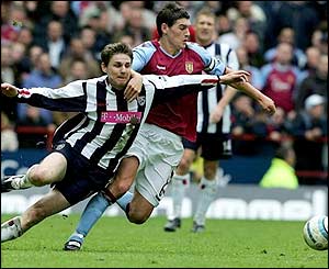 West Brom midfielder Zoltan Gera goes to ground as Gareth Barry muscles him off the ball