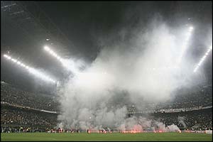 Smoke rises above the San Siro through flares