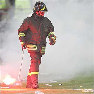A Fireman removes hundreds of object from the San Siro pitch