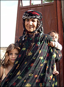 Woman carries young child on her back