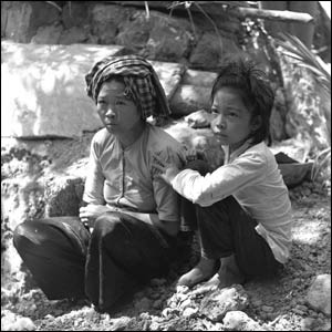 A Vietnamese mother and daughter come out of their shelter