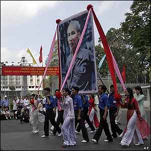 Youths parade holding large poster of Ho Chi Minh