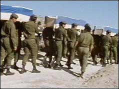 Soldiers bearing coffins on shoulders 