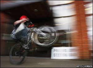 A youth performs a trick on his BMX outside a polling station in Surrey.