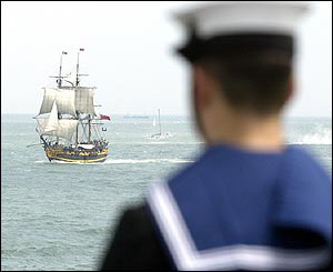 A sailor aboard HMS Invincible watching the tall ship Grand Turk