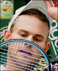 Andy Roddick inspects his racket