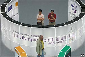 Visitors to the Olympic Museum exhibition look at maps and photos on display at the Raffles City Shopping Centre