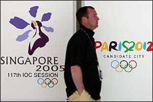 A member of the public walks past an advertising hoarding for Paris Olympic 2012 bid