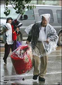 A Pensacola father and his daughter carry blankets and pillows into a shelter 