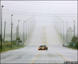 A lone car drives through the rains from Hurricane Dennis in Mobile, Alabama