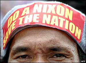 A protester with a sticker reading 'Do a Nixon - Save the Nation