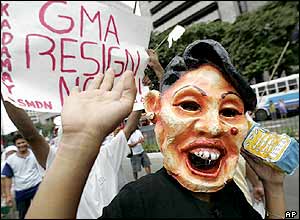 A protester wearing a mask of Philippine President Gloria Macapagal Arroyo joins thousands others during a rally calling for her resignation in the district of Makati, south of Manila on July 13, 2005