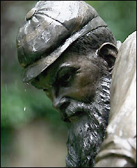 Rain drips off the cap of W G Grace's statue in the Coronation Garden at Lord's