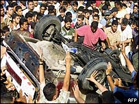 Palestinos protestam junto a carro atingido por ataque israelense