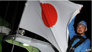 ناشط يرفع العلم الياباني قبالة جزر سينكاكو