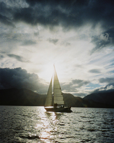 A yacht sailing into the sun