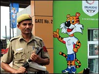 Milwr yn sefyll o flaen mynediad pentref y cystadleuwyr