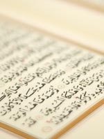 Arabic writing visible on the page of a Qur'an