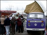 Shoppers standing next to campervan