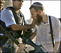 Policial israelense empurra colono armado durante protesto contra a retirada de Gaza