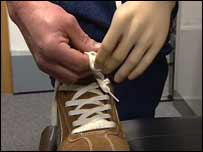 Man using artificial arm to tie shoelaces