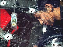 Tulkarim'de kurşunlanan arabayı inceleyen biri