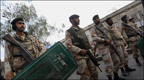 Pakistani paramilitary soldiers stand during an anti-government protest against an operation led by security agencies in Karachi on January 11, 2010