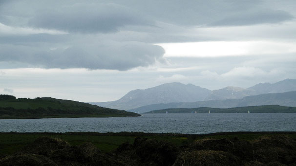 "At last, Arran begins to emerge from the low cloud. Fortunately, this picture doesn't display in smellovision - no prizes for guessing why the fields are so green!"