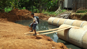 Crianças passam por cima de esgoto a céu aberto por meio de passarelas de madeira improvisadas (Fábio Pontes)
