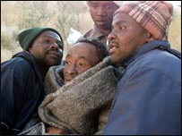 Enfermeiros carregam um paciente com Aids, um dia antes de ele morrer, na África do Sul