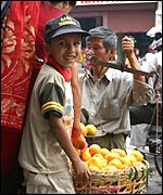 A child realises Ade has spotted him stealing an orange