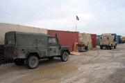 Army vehicles next to containers and tents on a British military base in Iraq