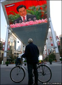 A passer-by watches President Hu's speech on a big screen in Beijing.