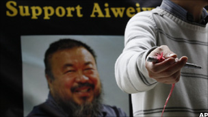 A pro-democracy protester holding a pen to urge residents to sign their names to support the release of Ai Weiwei in Hong Kong
