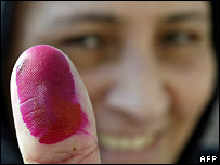 زن مصری انگشت جوهری خود را که نشان شرکت در انتخابات است بلند می کند