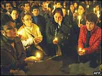 Moradores seguram velas em homenagem às vítimas dos ataques