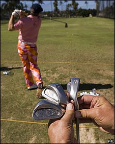 John Daly's caddy shows off some of the 20-year-old wedges while the player practises on the driving range