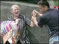 Елена Урлаева хавфсизлик ходимига қаршилик кўрсатаётир