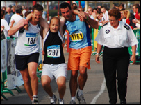 Other runners help a friend across the line