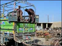 ٹرک سے کباڑ اتارا جا رہا ہے