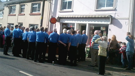 The local male voice choir helped celebrate the reopening of the local shop.