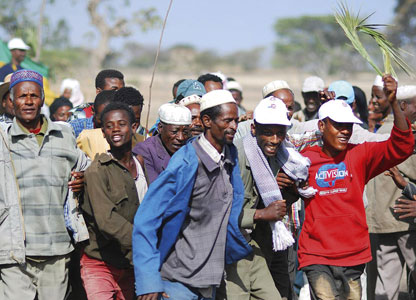 A crowd of delighted local people celebrate new wells coming into operation near Jima 