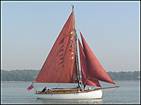 Sailing boat with red sail