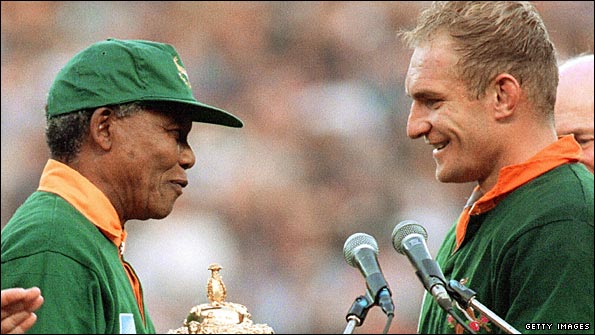 Francois Pienaar accepts the World Cup trophy from Nelson Mandela