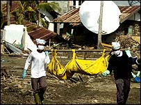 Banda Aceh'te enkaz altından çıkarılan cesedi taşıyanlar