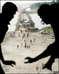 Equipes lançam suprimentos em um avião, sobrevoando o estado indiano de Bihar