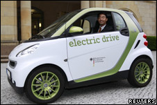 Germany's Economy Minister Philipp Roesler poses in an electric car