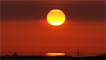 Sunset through the ash layer, as seen from Anglesey by John Rowlands