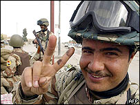 Irácký voják v Nadžafu má prsty do V na znamení vítěztsví