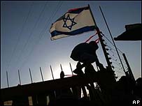 Colonos judeus contrários à retirada ajudam garoto a subir no portão do assentamento de Netzer Hazani